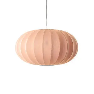 Oval koralfarvet lampe med strikket tekstur, hænger fra loftet i sort ledning.